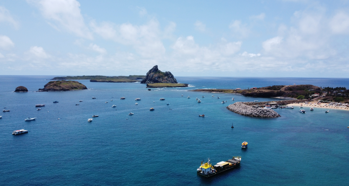 Uma vista aérea de um grande corpo de água com barcos nele. - Casa Pedrinho Noronha