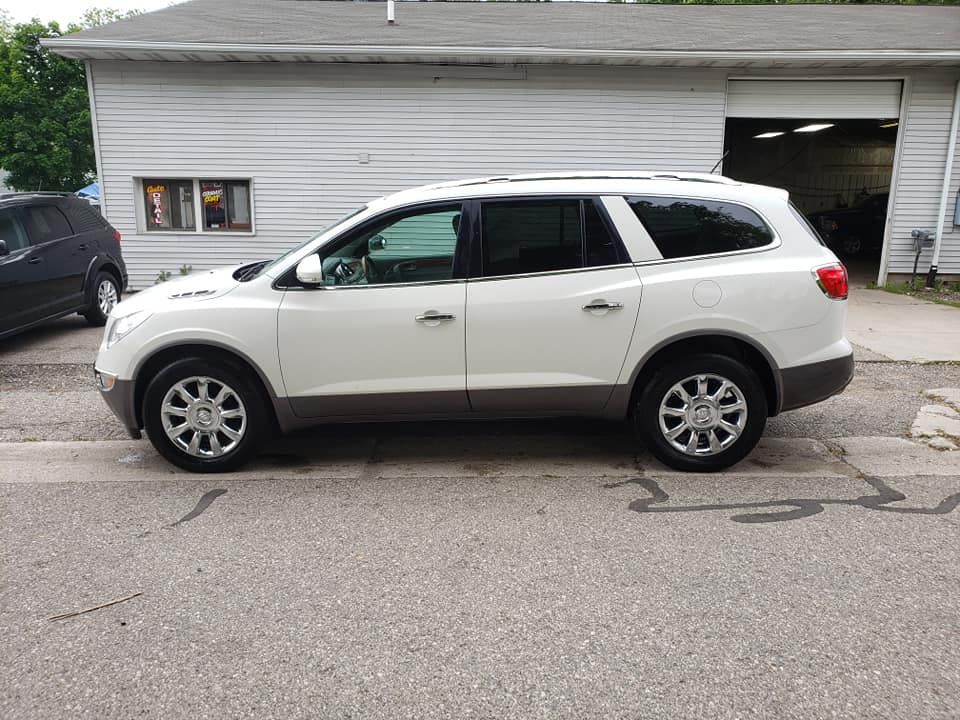 A white suv is parked in front of a garage.