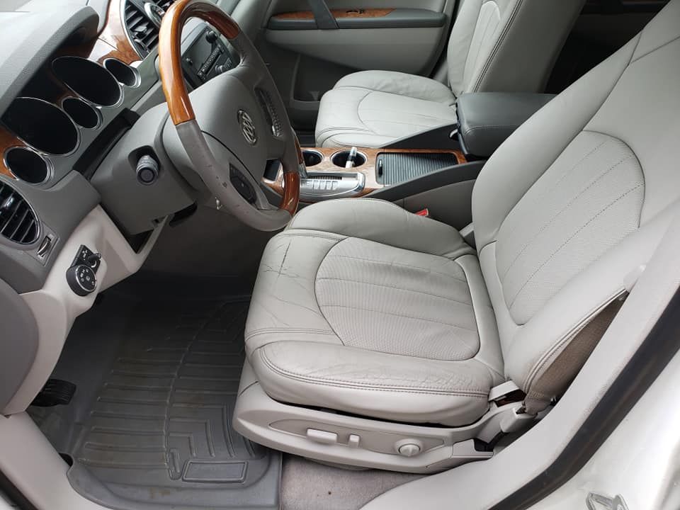 The interior of a white car with a wooden steering wheel
