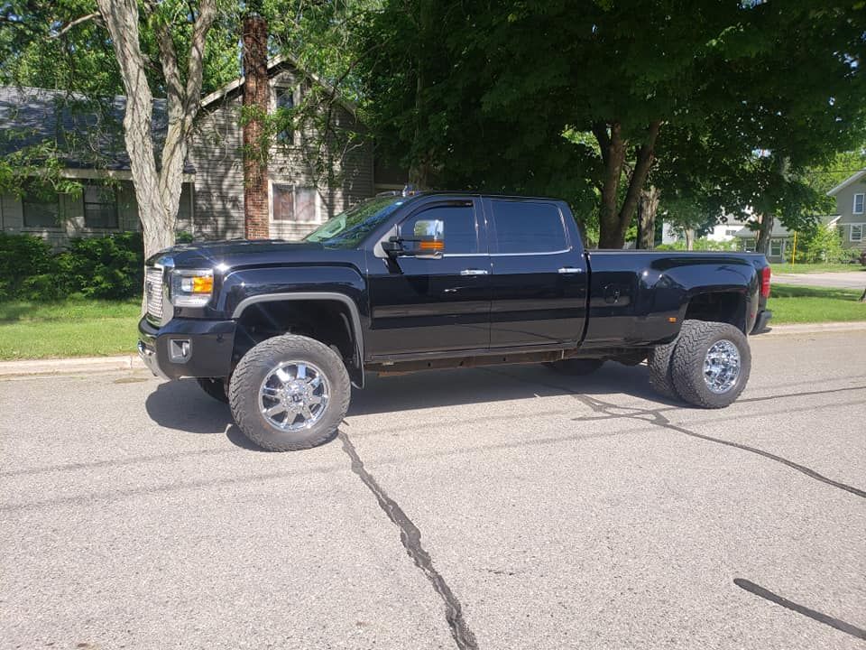 A black truck is parked on the side of the road.