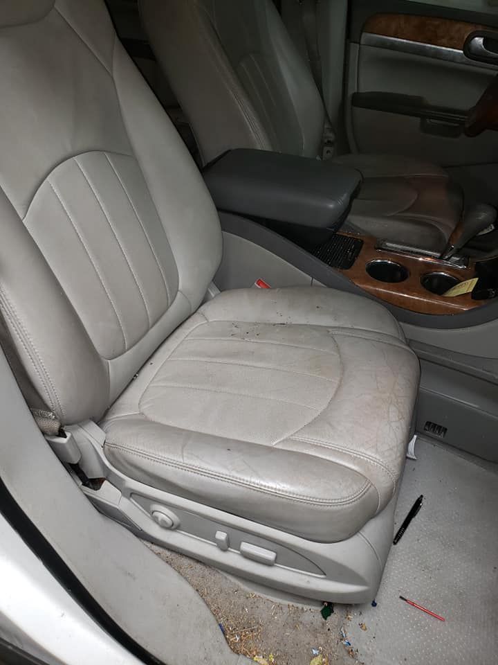 A car seat is sitting in the back seat of a car.