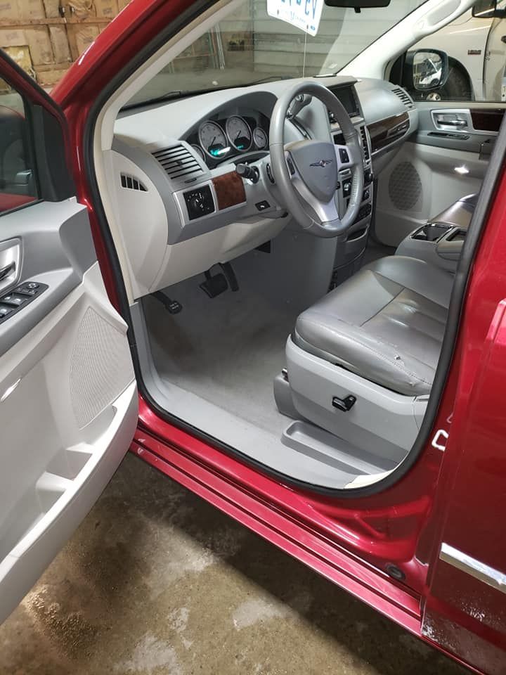The inside of a red car with the door open.