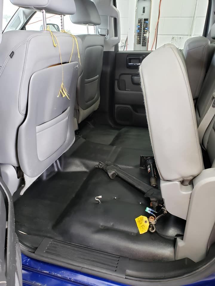 The inside of a blue truck with a yellow tag on the floor.