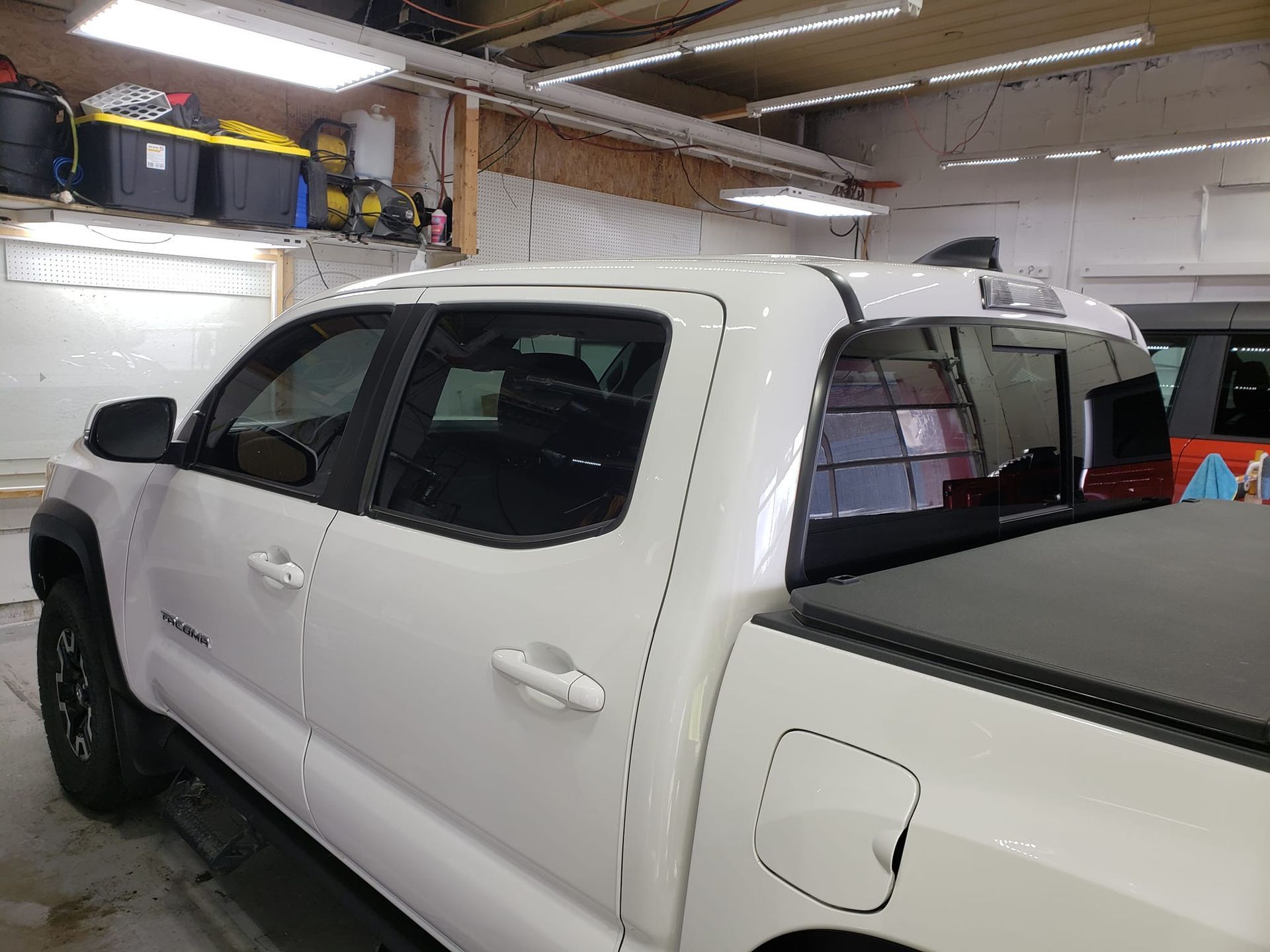A white truck is parked in a garage.
