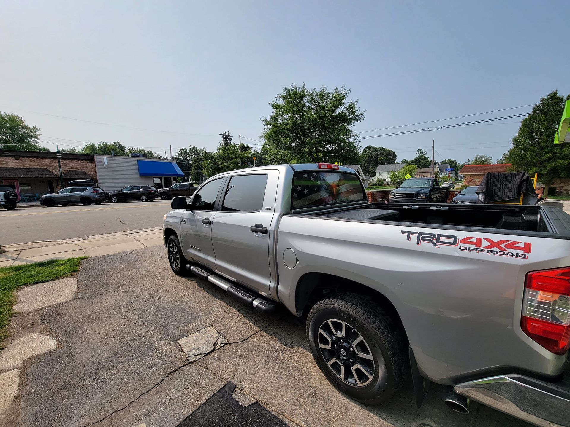 A silver toyota tundra truck is parked on the side of the road.