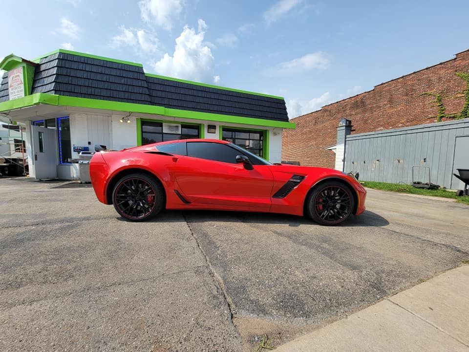 A red sports car is parked in front of a building.