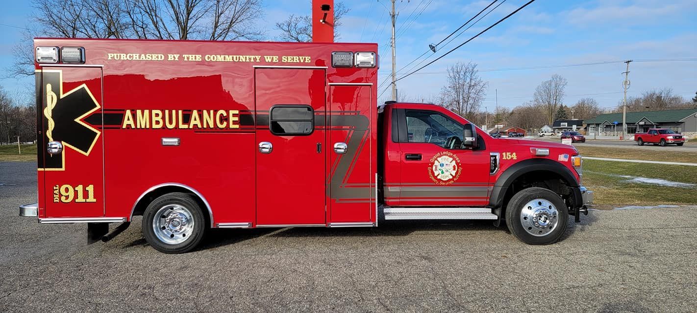A red ambulance is parked on the side of the road.