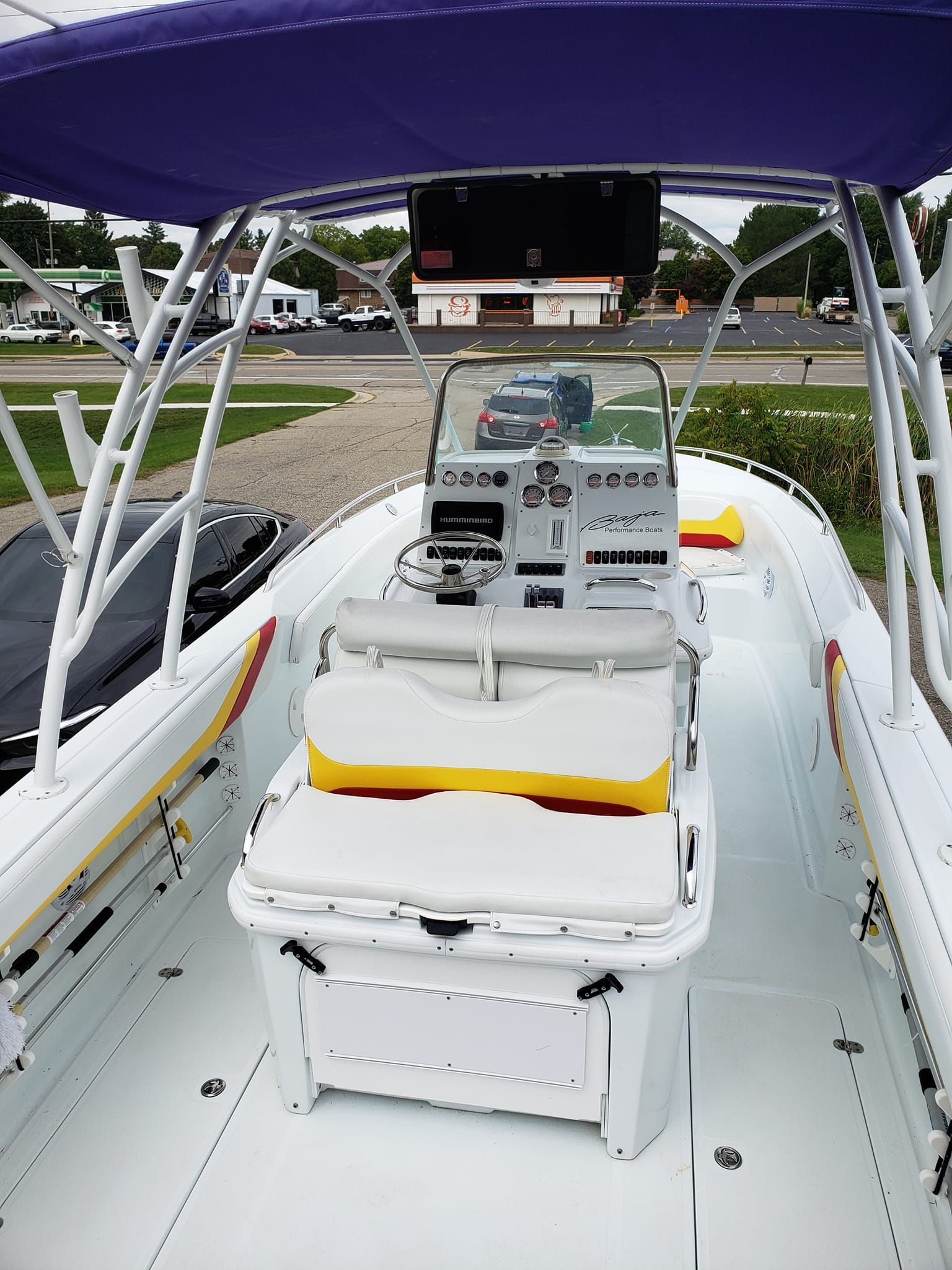 A white boat with a purple canopy on top of it