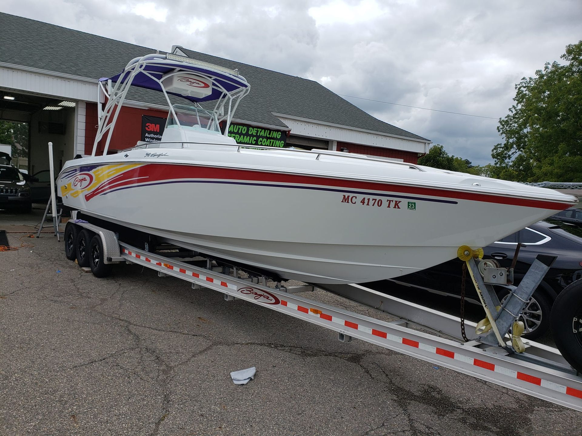A boat is sitting on a trailer in front of a building.