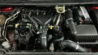 Compartimiento del motor del automóvil, componentes negros del motor, batería, entrada de aire y depósitos de líquidos.