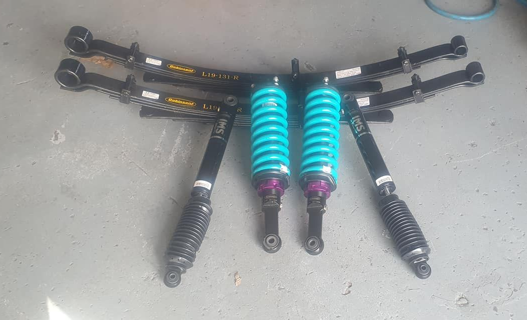 Four Black Vehicle Shock Absorbers With Teal Springs — Coopers Auto Care in South Lismore, NSW