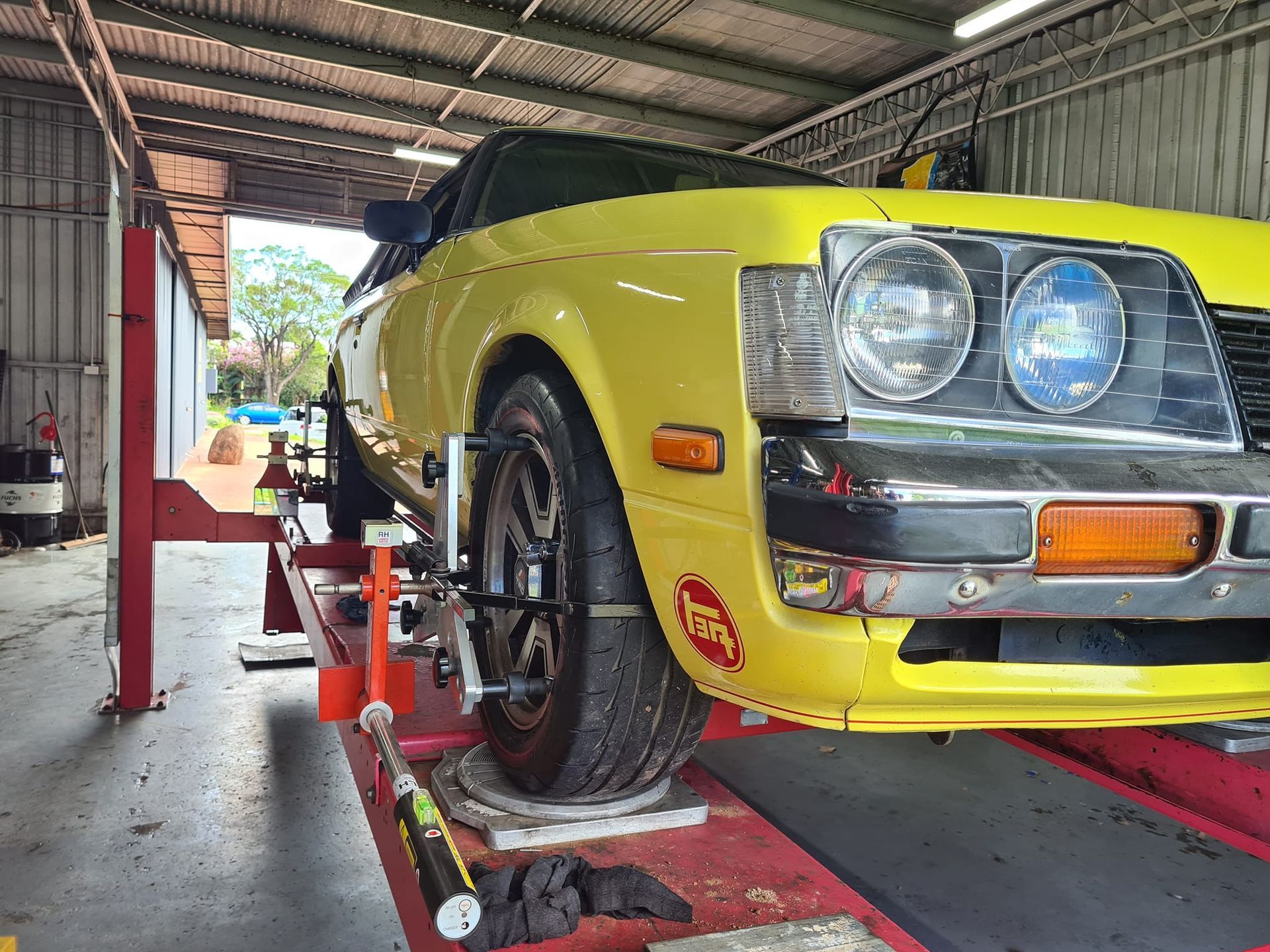 Yellow Classic Car on a Car Lift — Coopers Auto Care in South Lismore, NSW