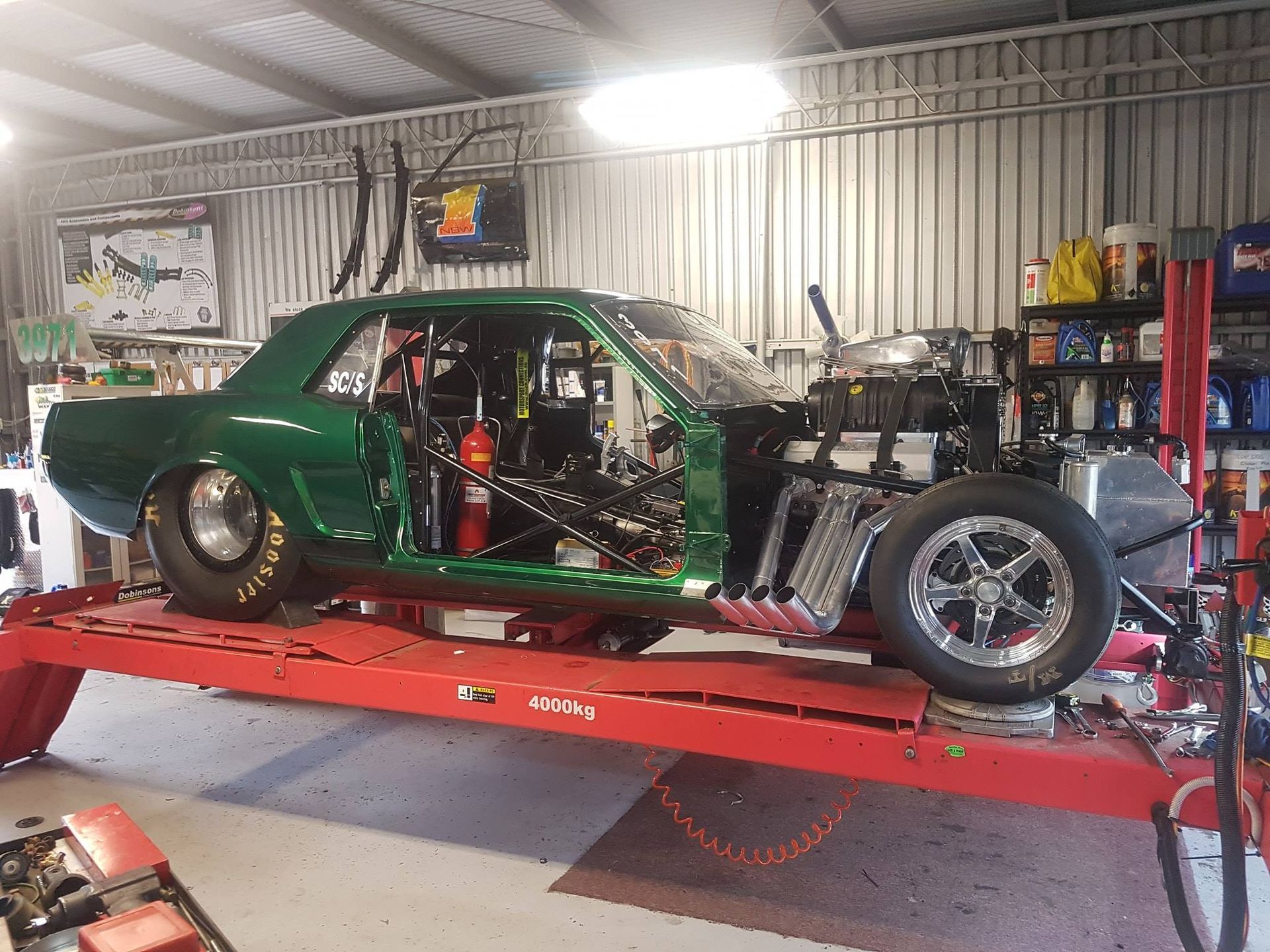 Green Race Car on a Red Lift in a Garage — Coopers Auto Care in South Lismore, NSW