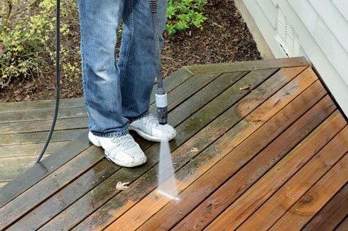 Flooding Foundations — Man Pressure Washing the Deck in Manchester, CT