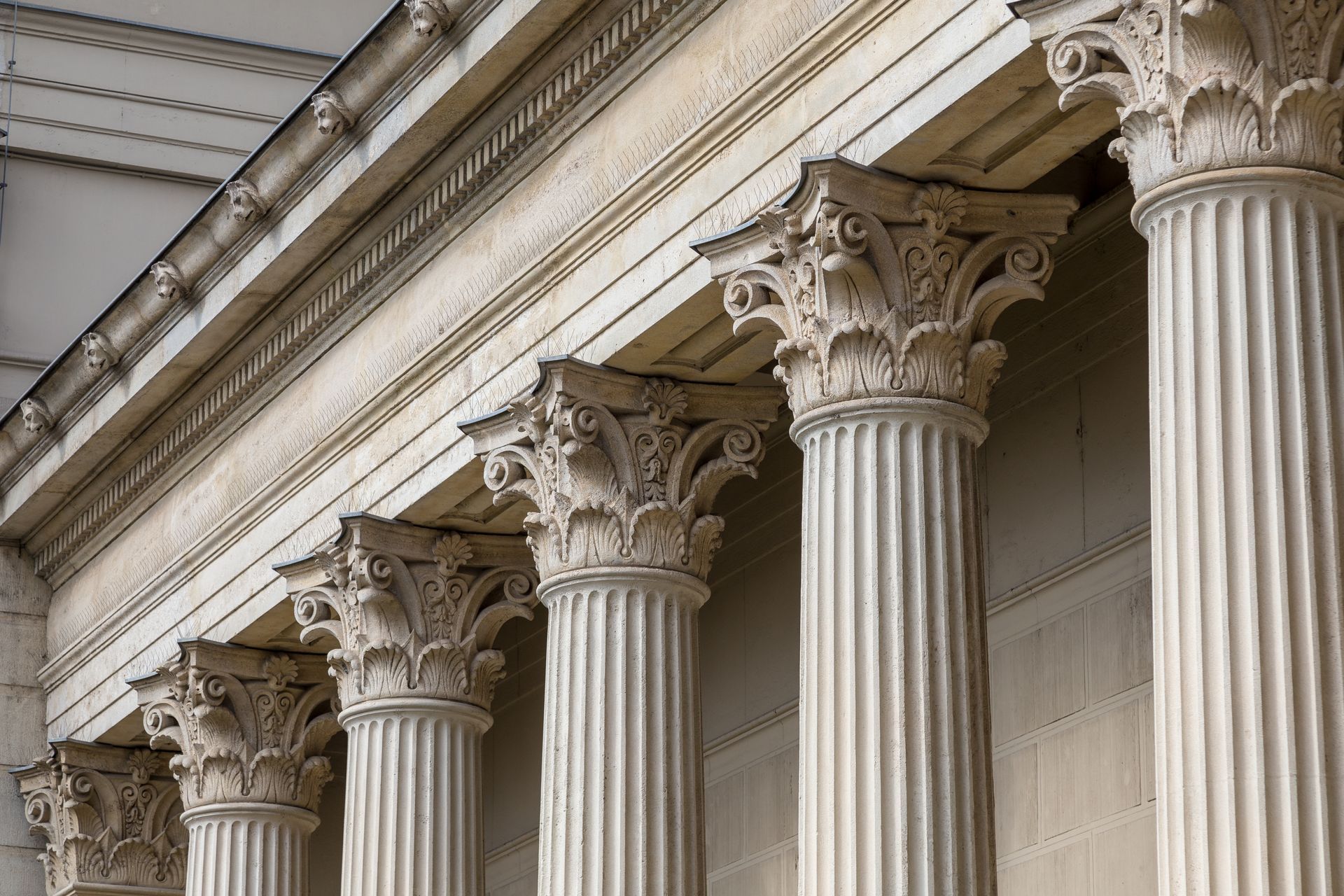 Ornate classical columns supporting a white stone building façade