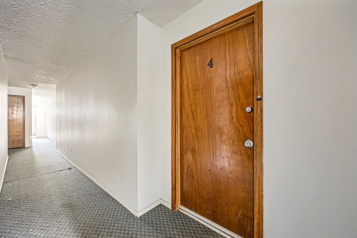 Hallway with wooden door labeled 