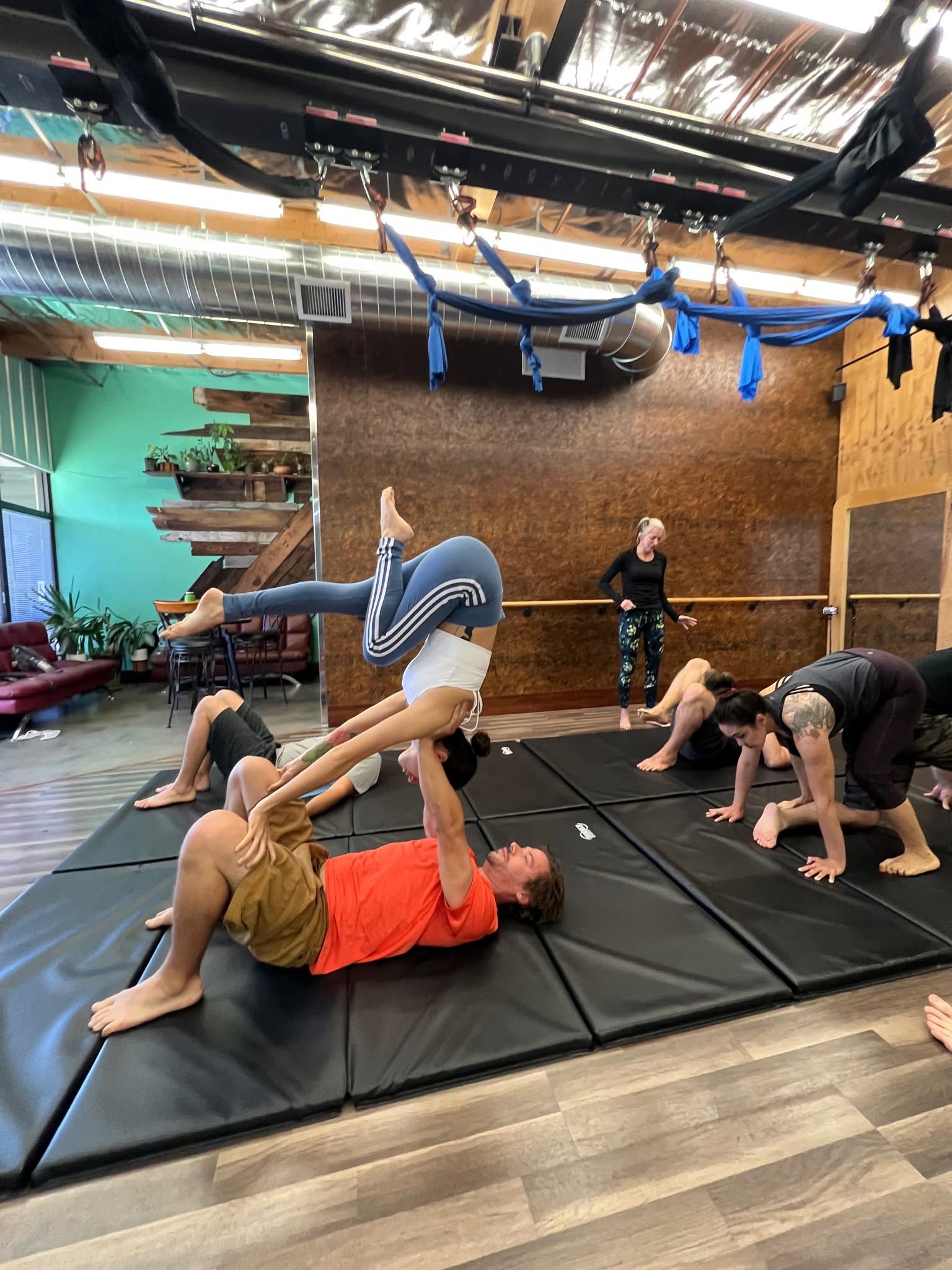 People stretching on mats in a gym studio during a fitness class