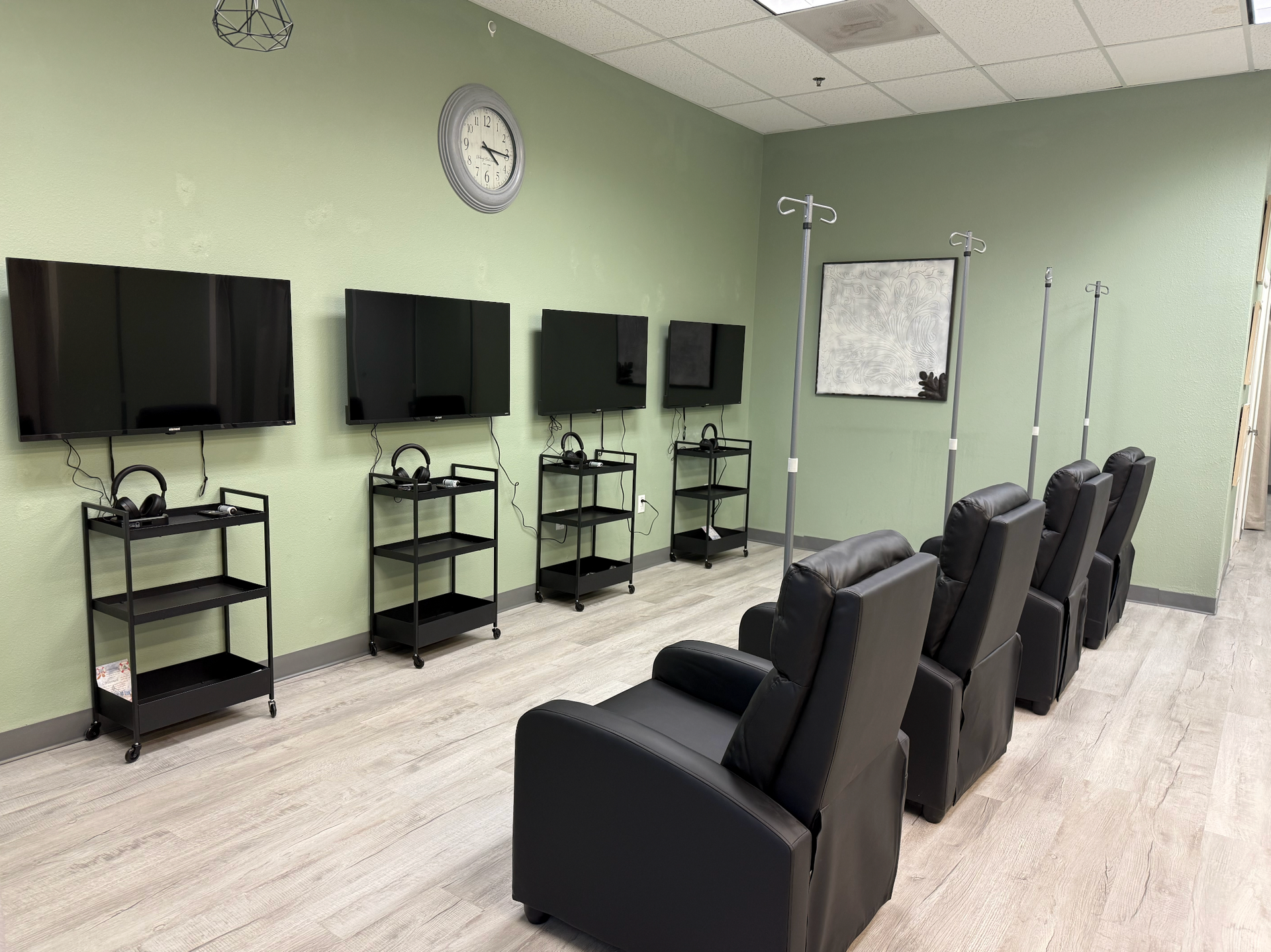 A room with reclining chairs, TVs, and IV poles, suggesting a medical or therapy setting. Level Up Falcon