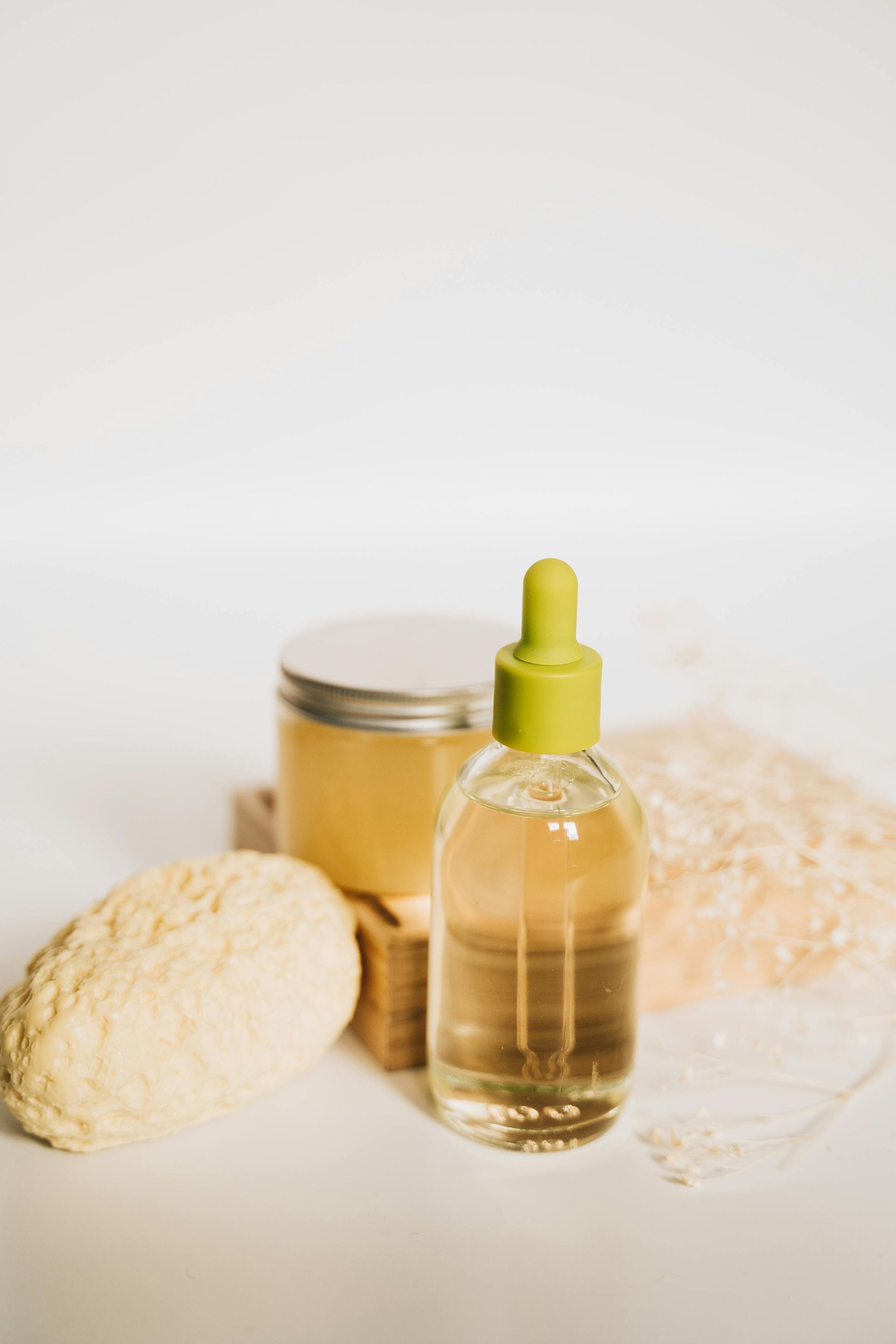 Clear bottle with dropper, jar, loofah, and net on white background. Level Up Falcon