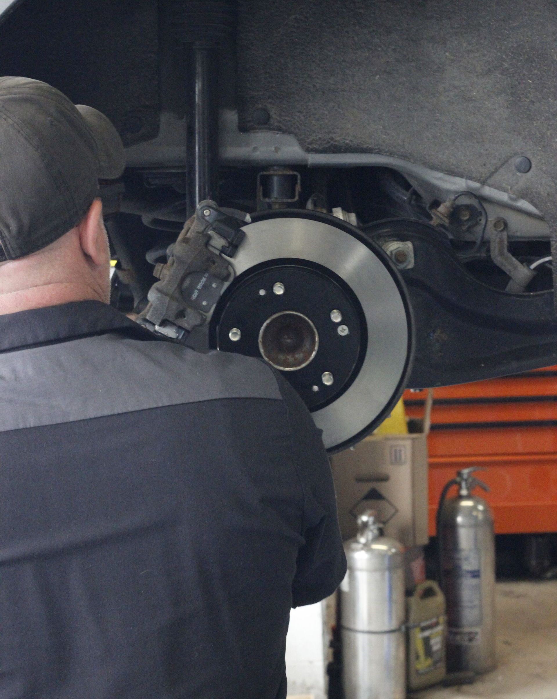 Mechanic inspecting car brakes