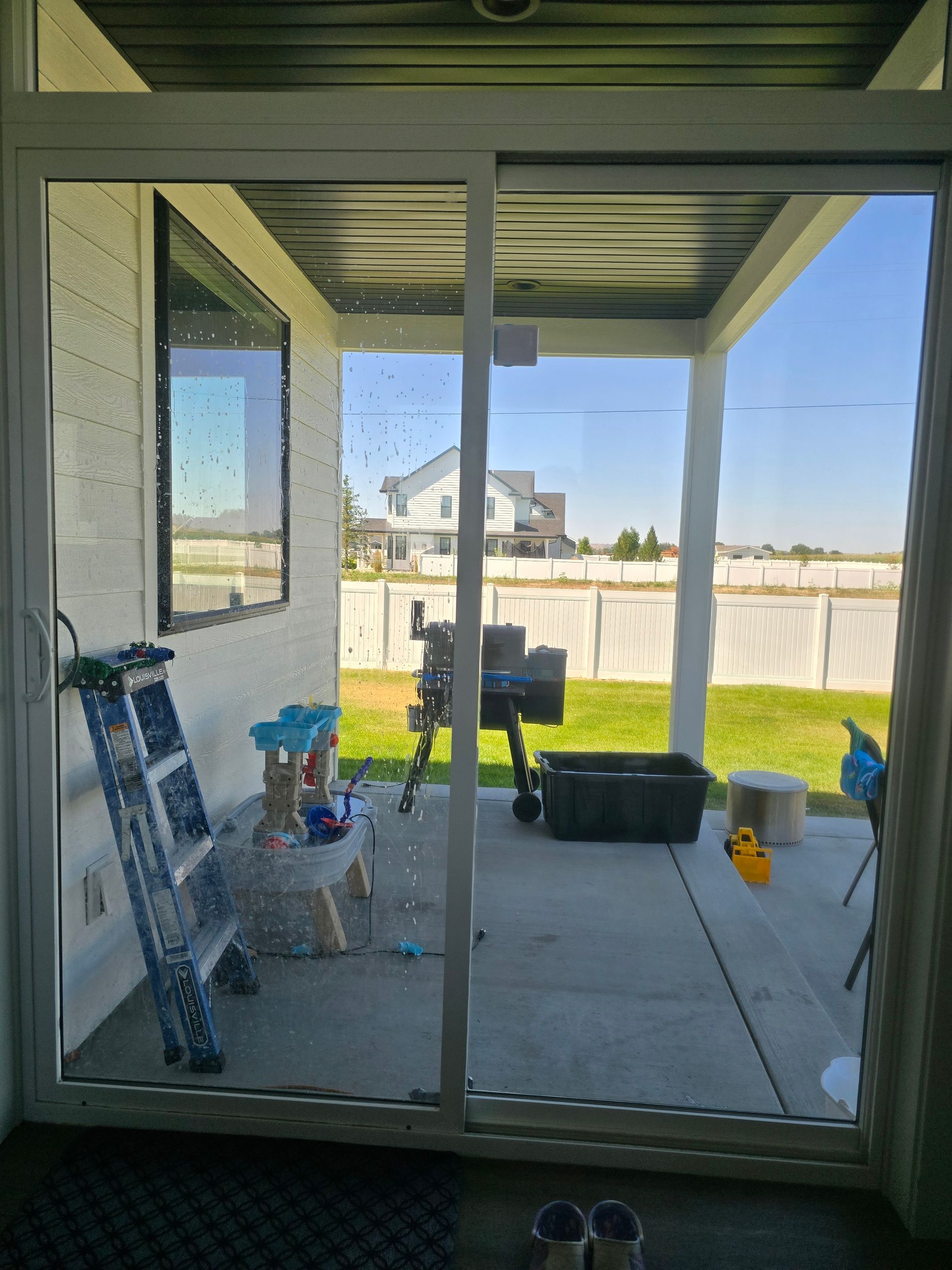 A screened in porch with a ladder and a grill
