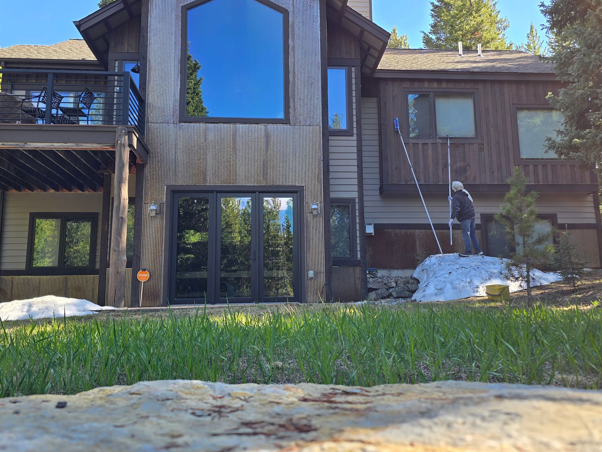 A man is skiing in front of a large house.