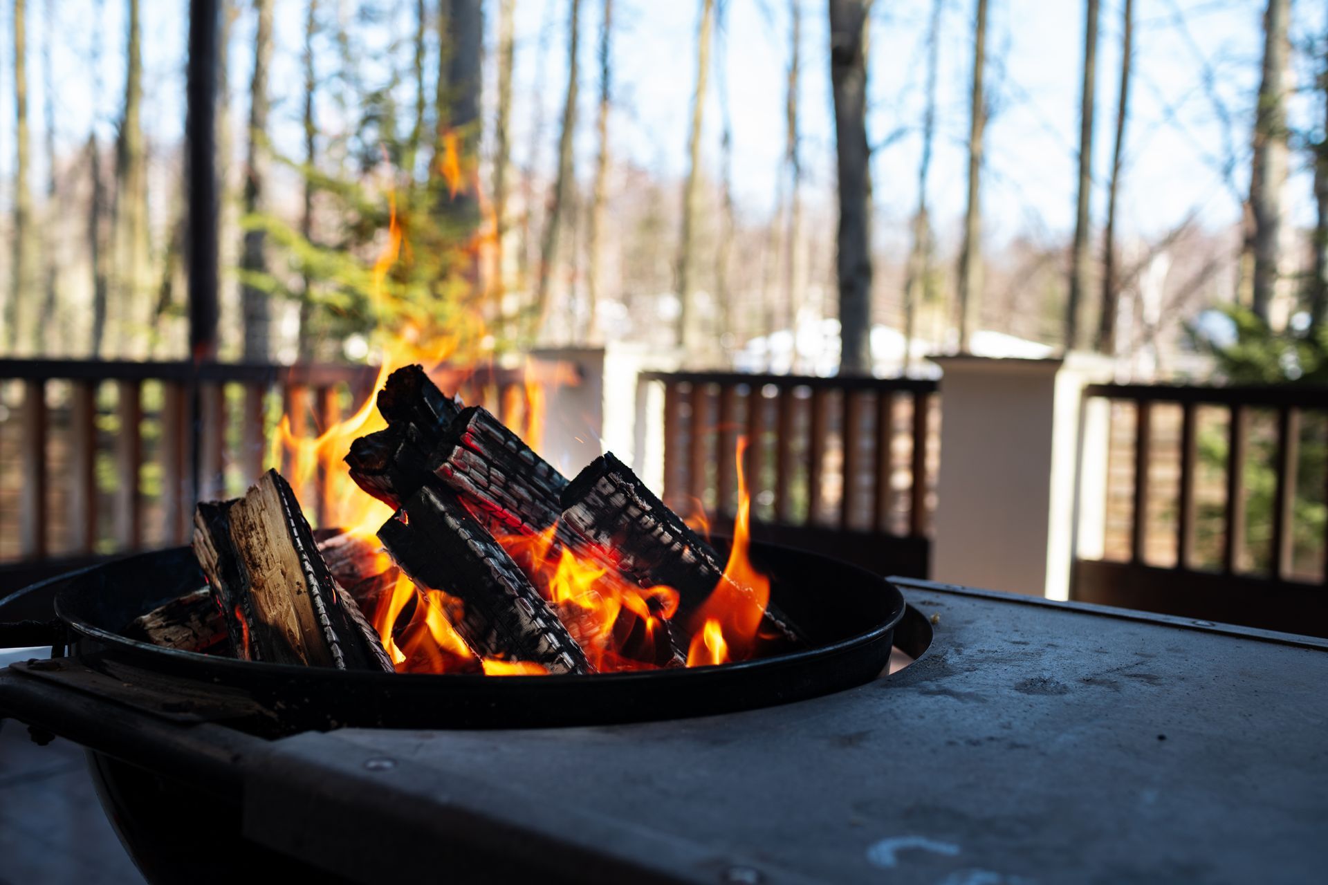A fire pit filled with logs is sitting on a table.