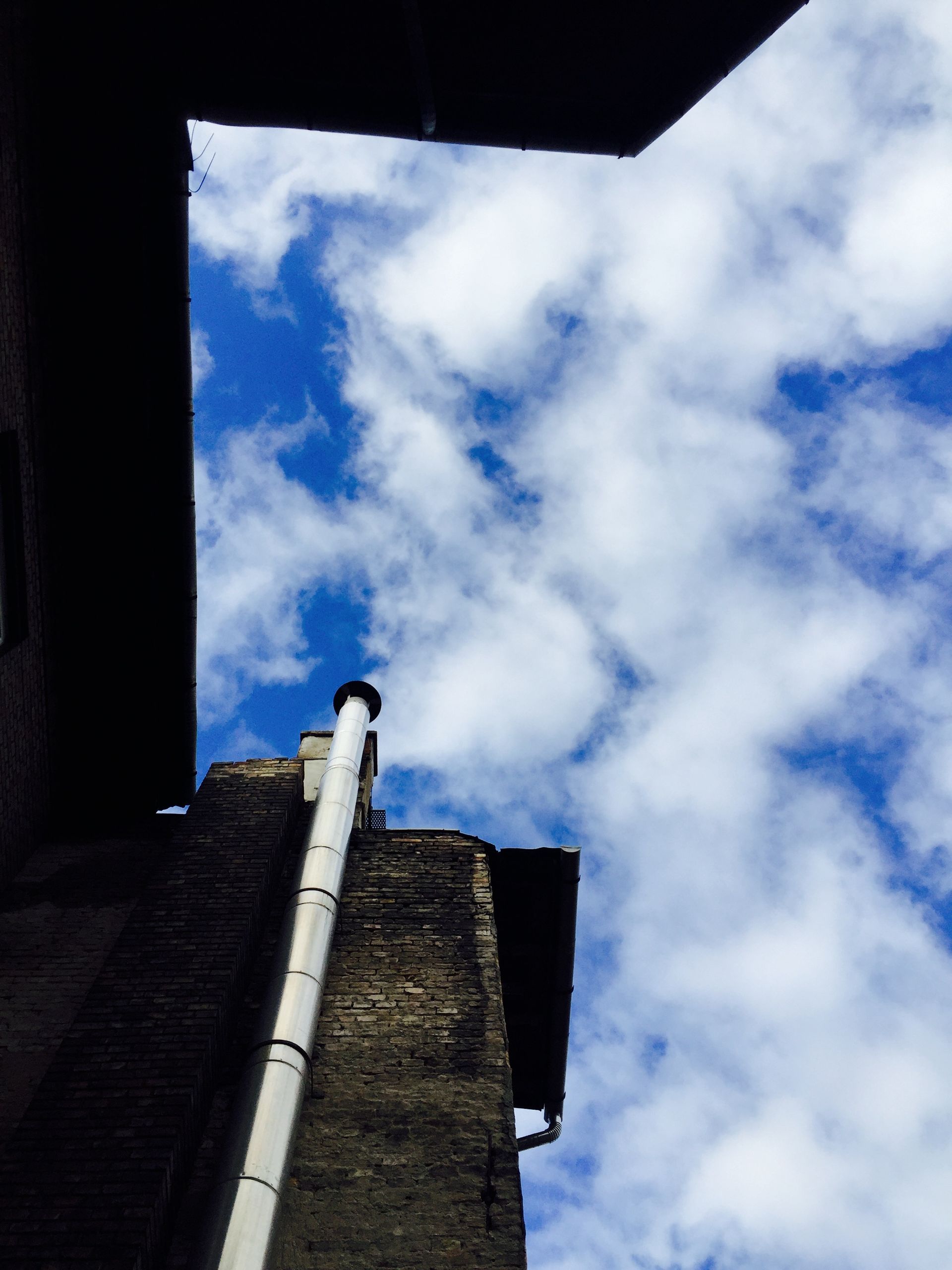 Looking up at a chimney with a blue sky in the background