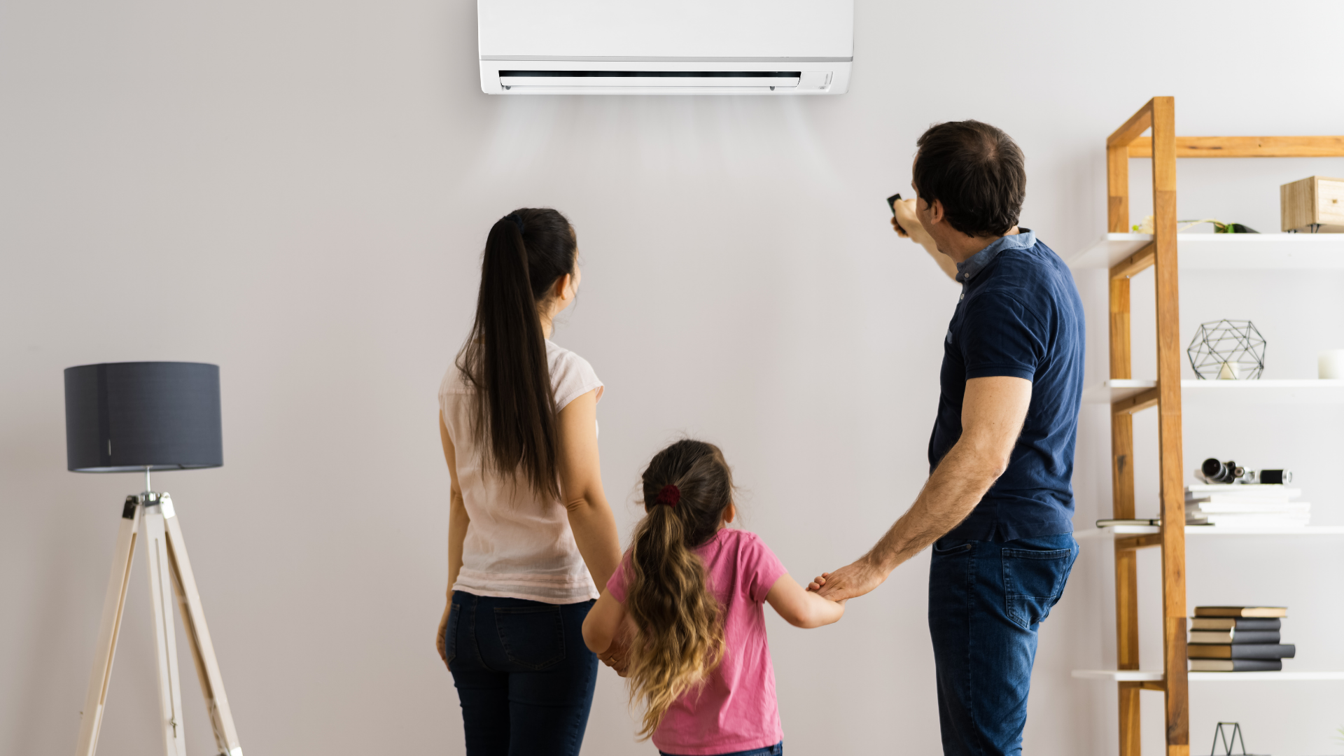 A family is standing in front of a wall mounted air conditioner.