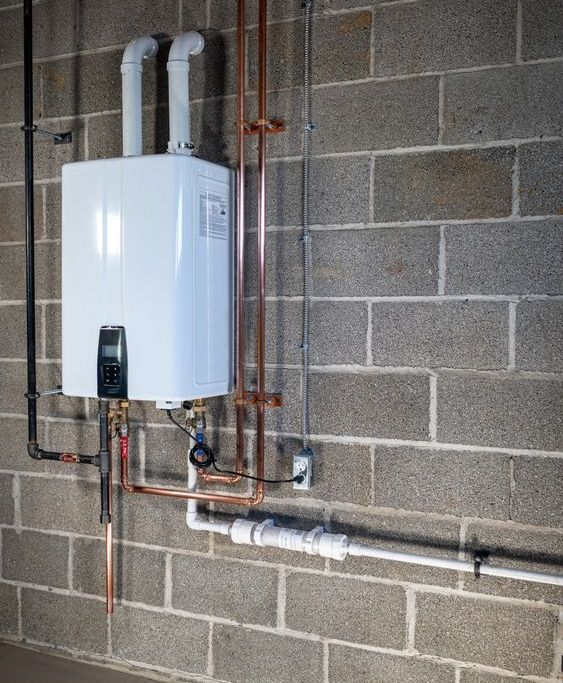 A white water heater is mounted to a brick wall