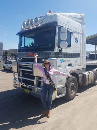A Woman In A Cowboy Hat Is Standing In Front Of A Semi Truck — RJN Transport In Coonabarabran, NSW
