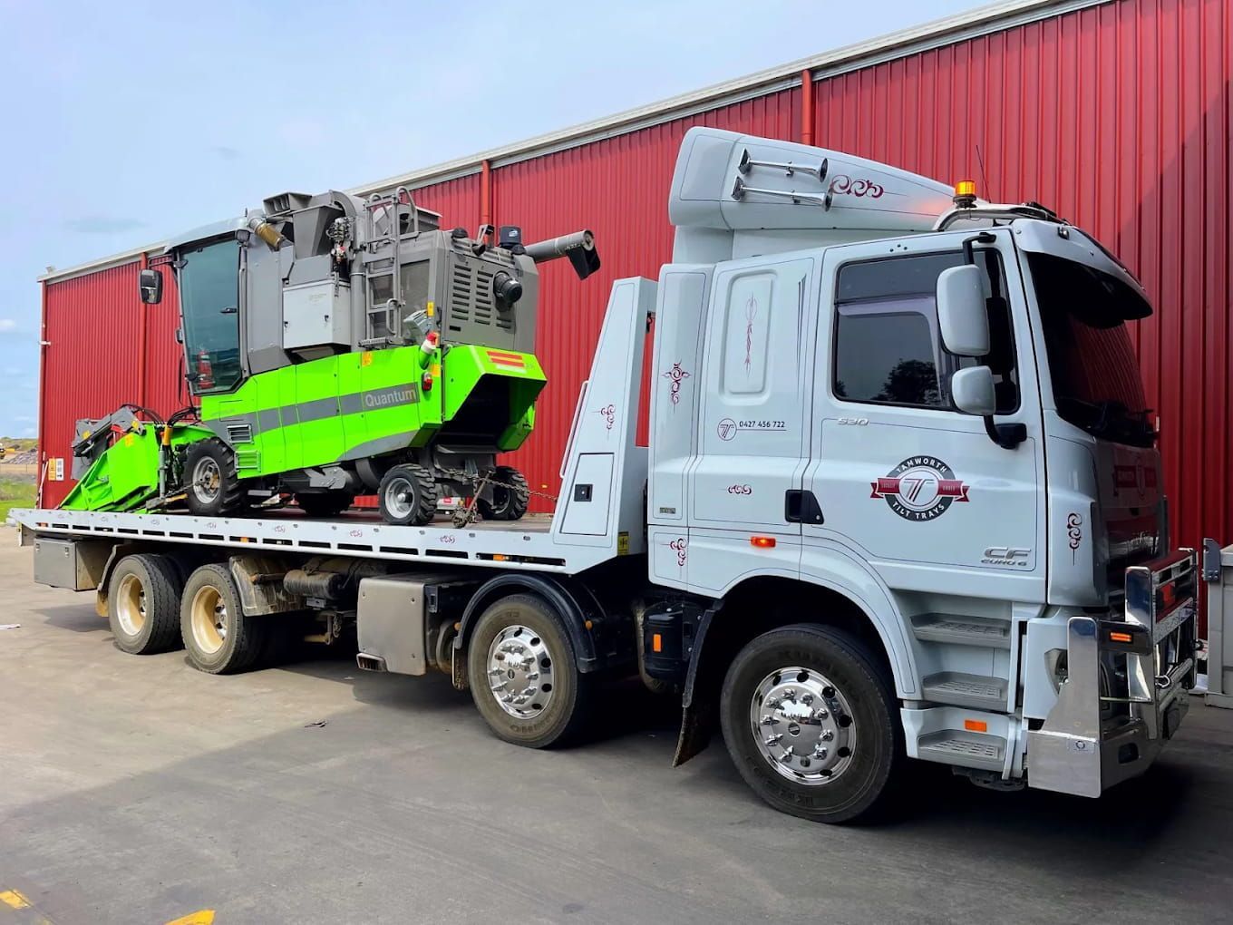 A Red Semi Truck Is Driving Down A Highway — RJN Transport In Tamworth, NSW