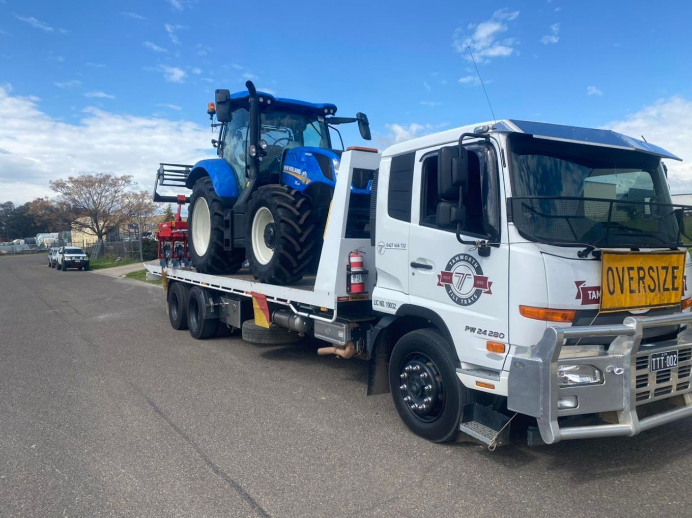 A Semi Truck Is Carrying A Combine Harvester Down A Highway — RJN Transport In Tamworth, NSW