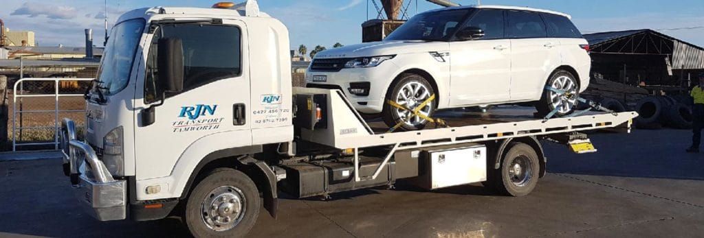 A Tow Truck Is Carrying A Range Rover On The Back Of It — RJN Transport In Armidale, NSW