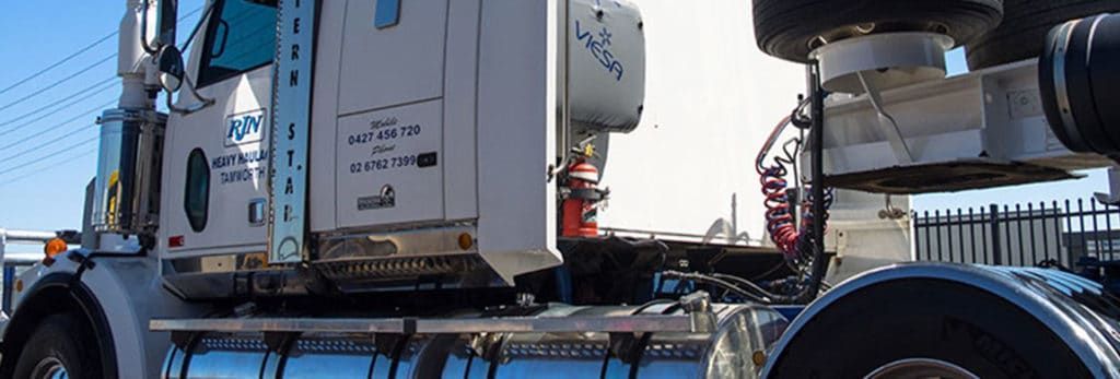 A White Semi Truck Is Parked In Front Of A Fence — RJN Transport In Glen Innes, NSW