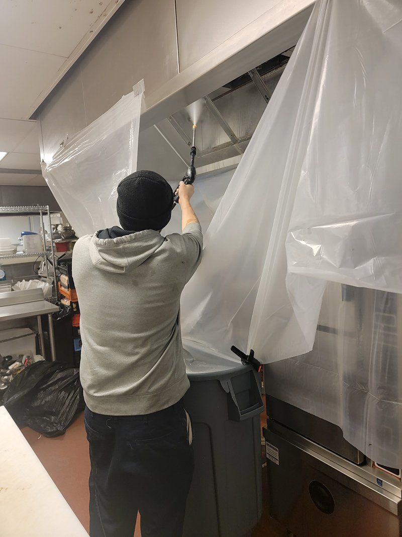 Worker Cleaning The Kitchen Exhaust — Springfield, MA — Advanced Air Quality, Inc.