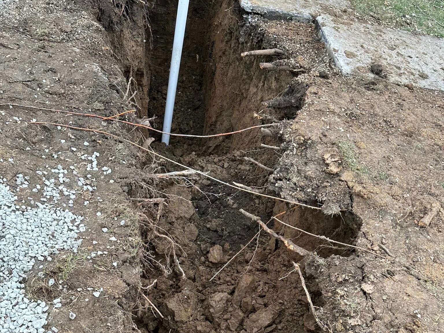 A pipe is sticking out of a hole in the ground.