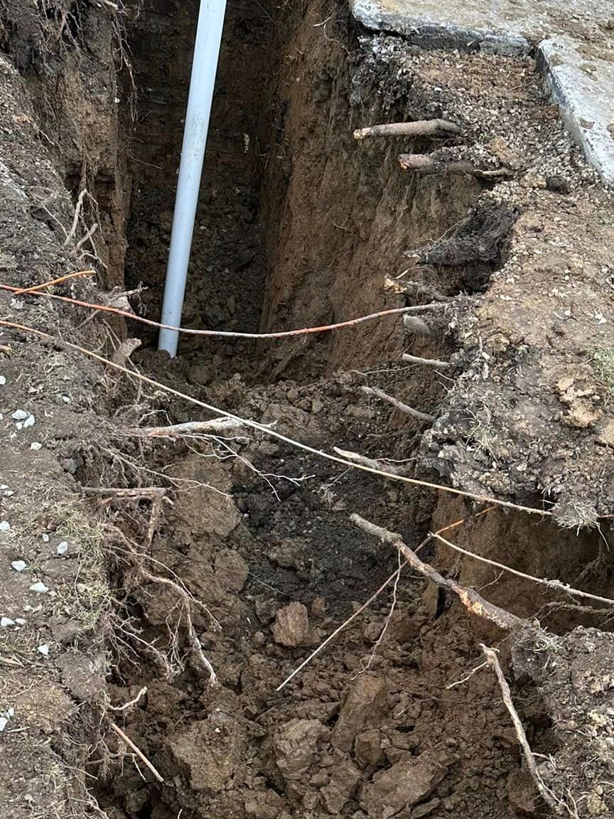 A pipe is sticking out of a hole in the ground.