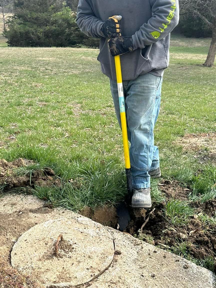 A man is digging a hole in the ground with a shovel.