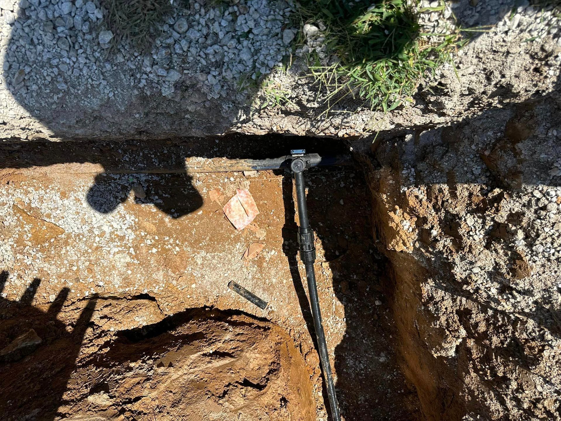 A person is digging a hole in the ground with a shovel.
