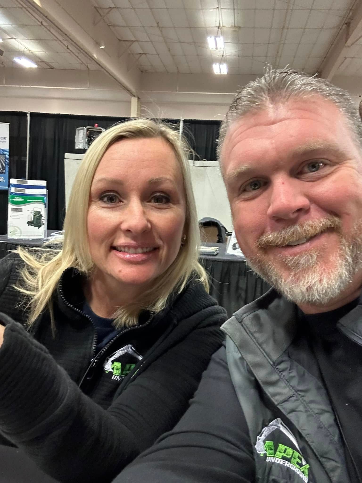 A man and a woman are taking a selfie in a room.