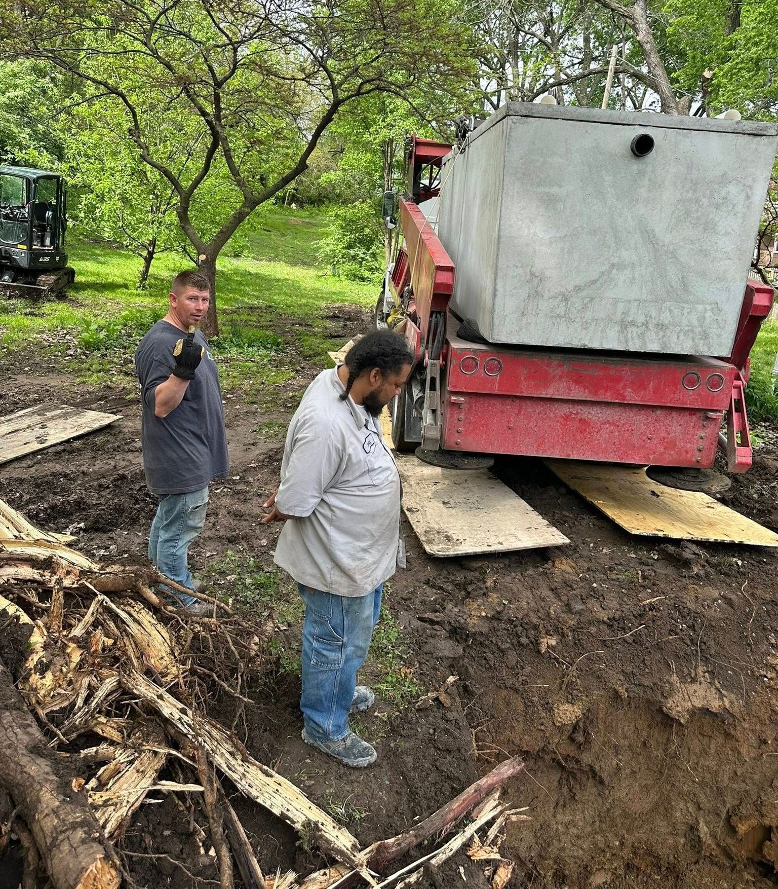 A man is digging a hole in the ground in front of a house.