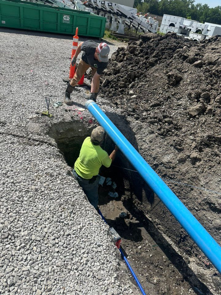 A man is digging a hole in the ground in front of a house.