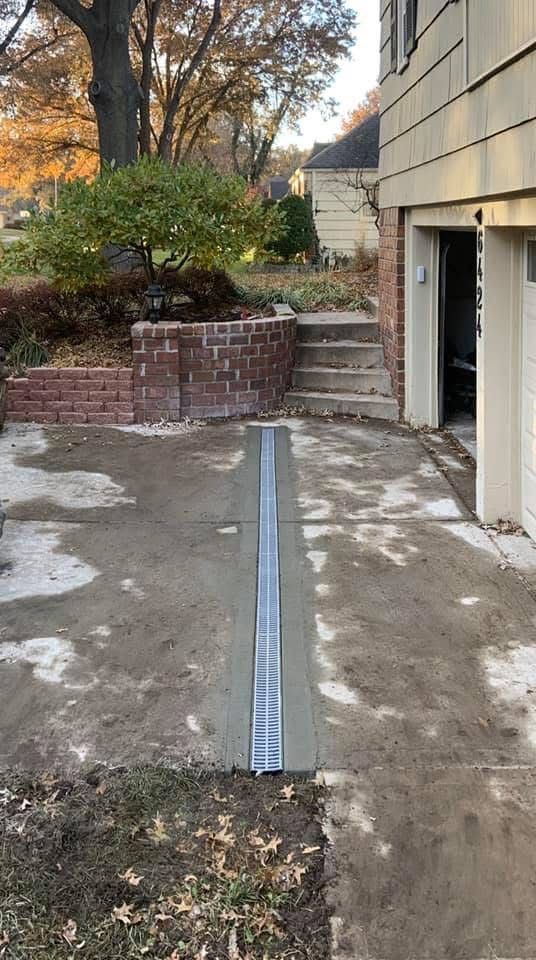 A concrete driveway is being built in front of a house.