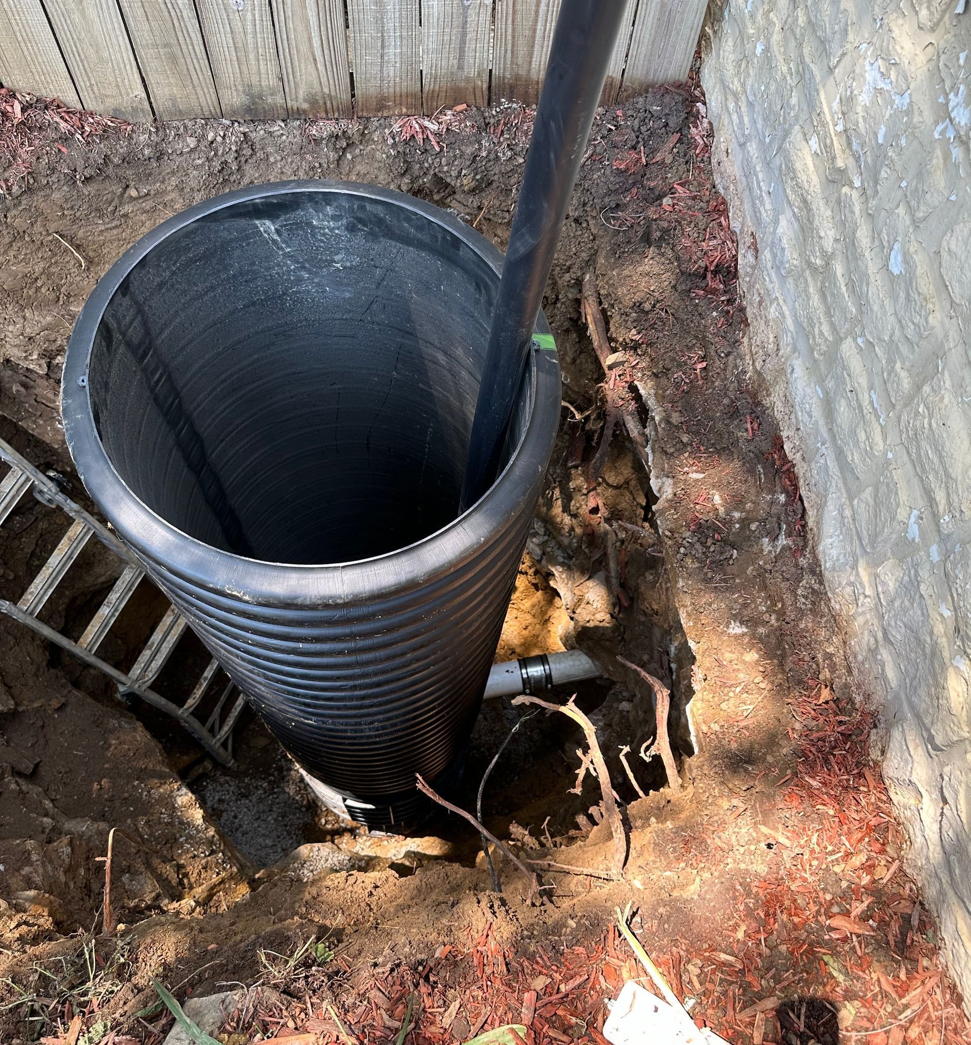 A man is digging a hole in the ground in front of a house.