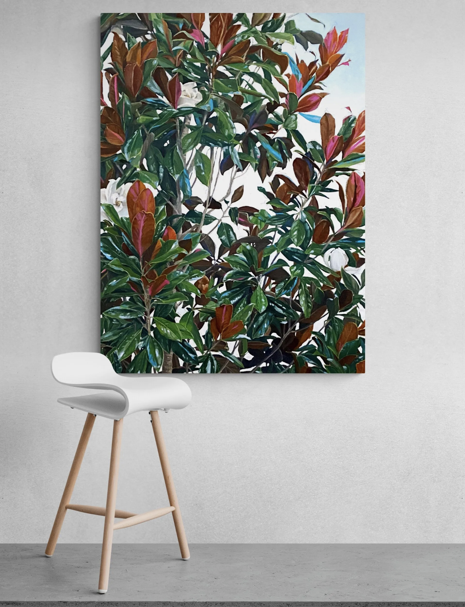 A white chair is sitting in front of a painting of a tree.