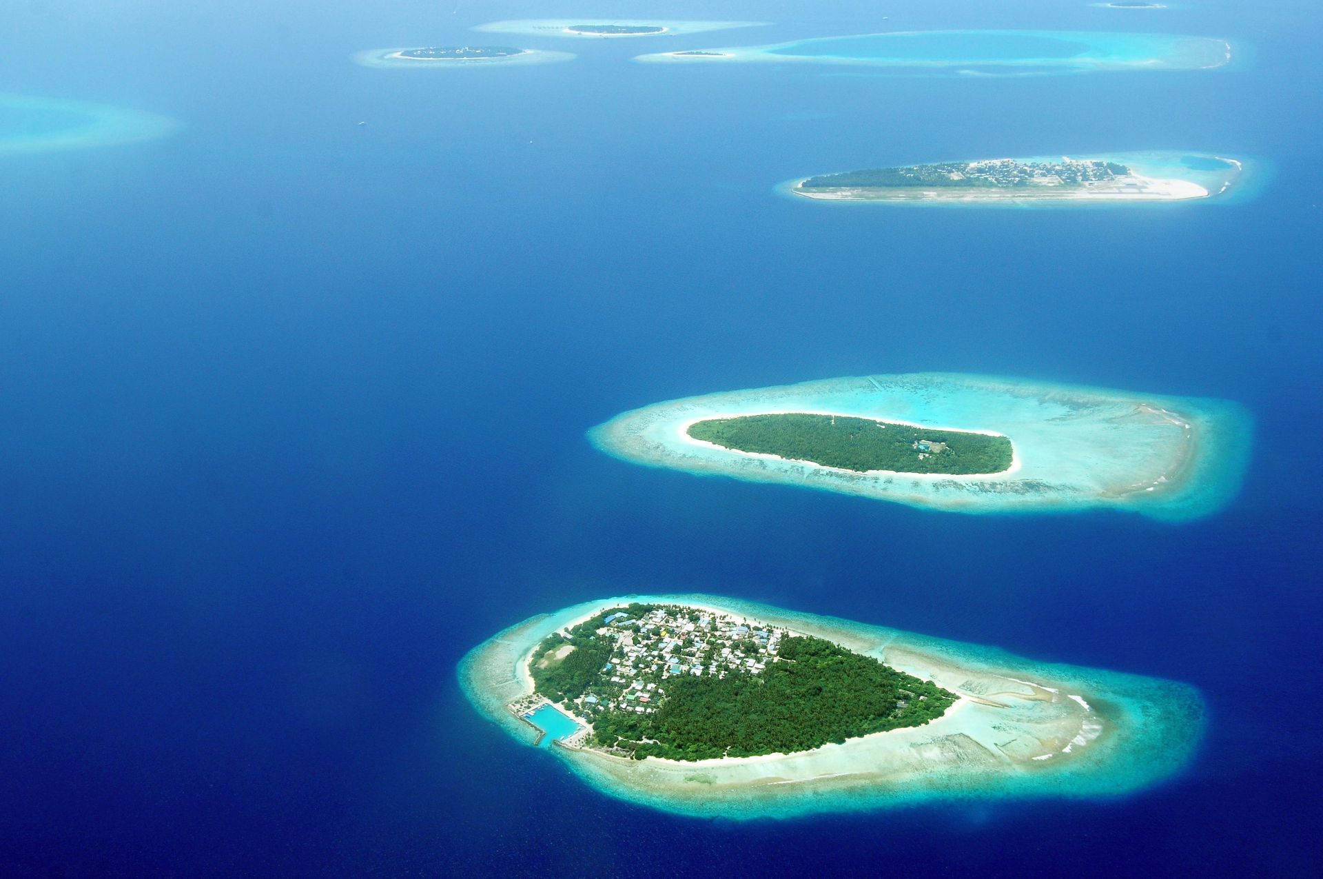 Several tropical islands surrounded by turquoise and deep blue ocean.