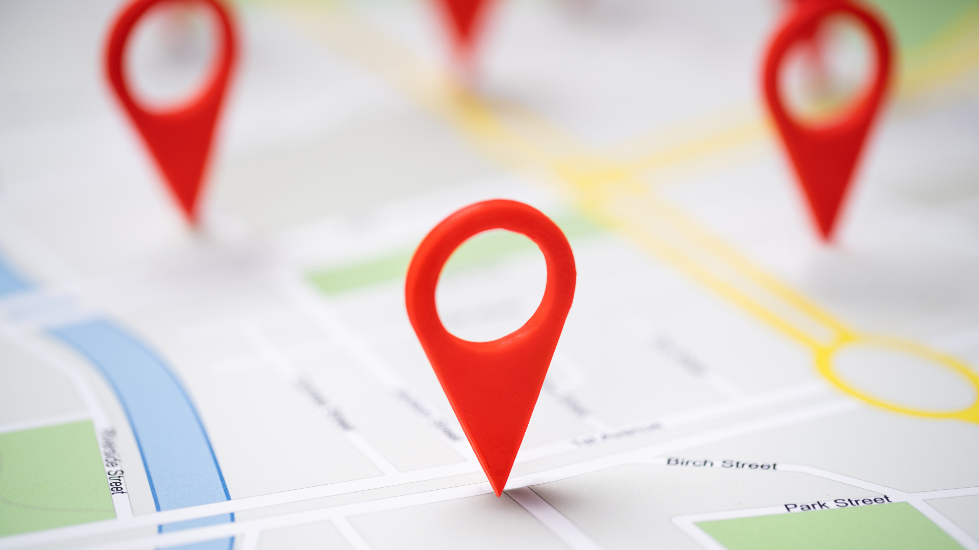 A close up of a map with red pins on it.