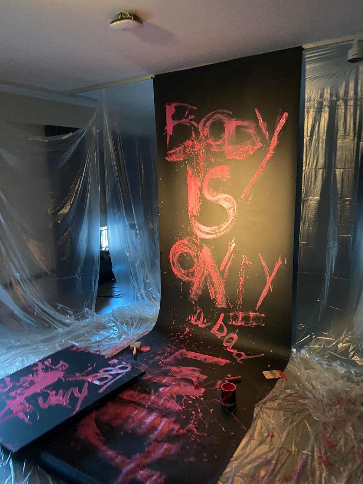 Una stanza con un dipinto sul muro che dice ``il corpo è solo''.