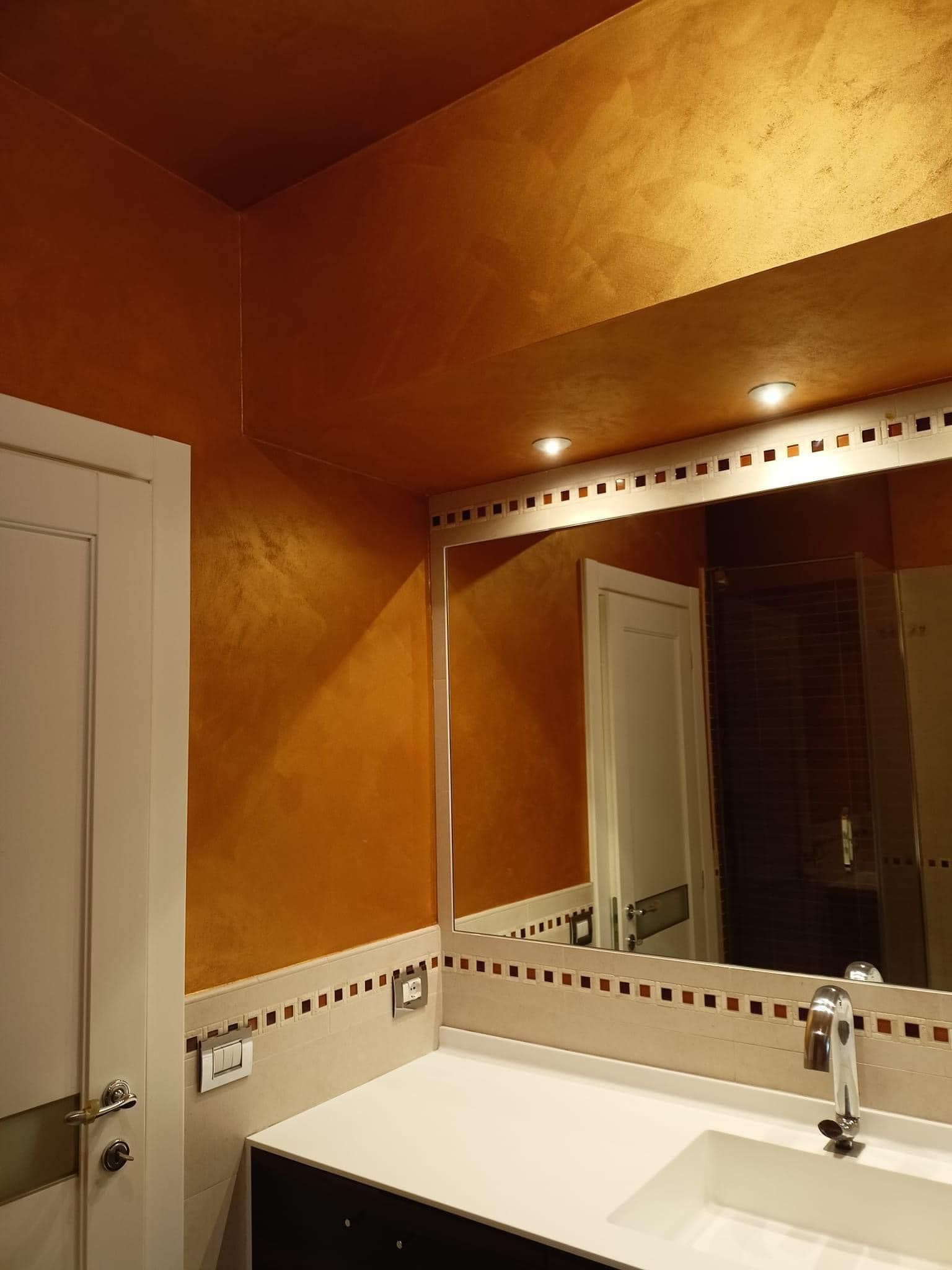 Un bagno con un lavandino e un grande specchio